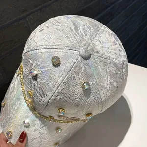 Detail of white lace baseball cap with colorful rhinestones and gold diamond chain