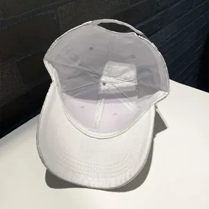 Detailed interior of a white baseball cap showing six-panel stitch and adjustable strap