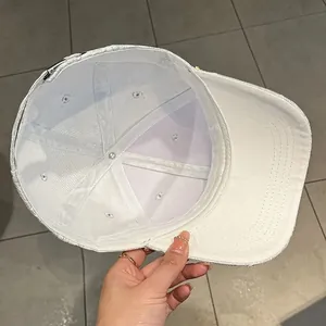 Dettaglio dell'interno del cappellino bianco con cuciture rifinite e fibbia regolabile