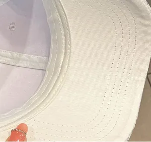 Dettaglio della visiera del cappellino bianco con cuciture rinforzate a sei file visibili