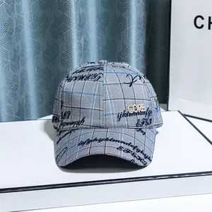 Detail of grey plaid baseball cap featuring rhinestone CORE lettering and graphic prints