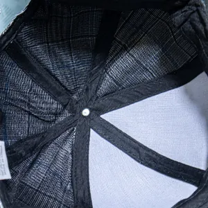 Detail view of baseball cap interior with plaid lining and reinforced black seams