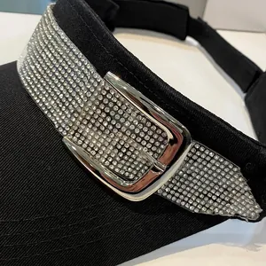Detailopname van zwarte zonneklep met strassband en een zilverkleurige metalen gesp-accent