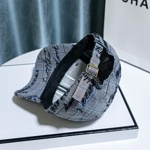 Detail of plaid baseball cap with script print and adjustable gold metal buckle back