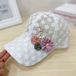 Detailed view of white mesh lace baseball cap with handmade floral and deer accents