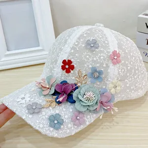 Detailed view of white mesh lace baseball cap with vibrant 3D floral and gold leaf accents