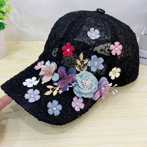 Detail of black lace baseball cap featuring 3D fabric flowers and gold leaf accents
