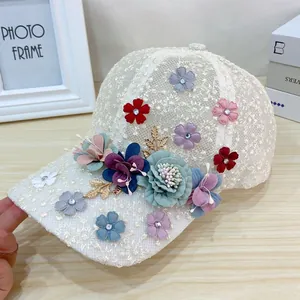 Detailed macro of white lace baseball cap with handmade floral embroidery and rhinestones