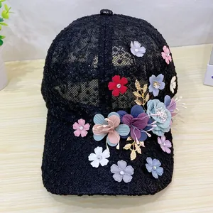 Detail of colorful 3D flowers and golden leaf accents on black mesh baseball cap