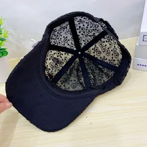 Detailed interior of a black lace baseball cap with mesh fabric and floral embroidery