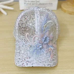 Close-up of 3D floral embroidery with pearls and sequins on white mesh baseball cap