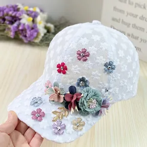 Detailed shot of 3D fabric flowers and golden leaves on white mesh baseball cap