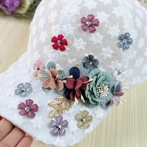 Close-up of white organza lace baseball cap featuring 3D floral embroidery and rhinestones