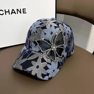 Detailansicht der floralen Spitzen-Baseballkappe mit funkelndem Strass-Schmetterling
