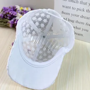 Detail of white organza floral lace mesh and structured brim on breathable baseball cap