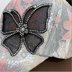 Detailaufnahme der Spitzen-Baseballkappe mit glitzernder Strass-Schmetterlingsstickerei