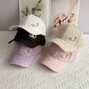 Detail of five floral jacquard baseball caps with pearl heart metal ornaments in various colors