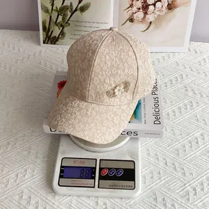 Detailed view of apricot lace baseball cap with pearl heart buckle weighing 88 grams