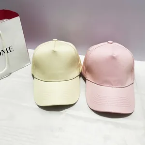 Classic five-panel cotton baseball caps in cream and pink colors with copper buckles
