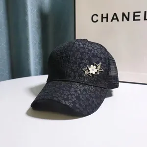 Detail of black lace baseball cap with sparkling star brooches and floral patterns