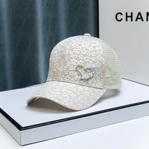 Detail of floral embroidery and pearl heart decoration on beige baseball cap