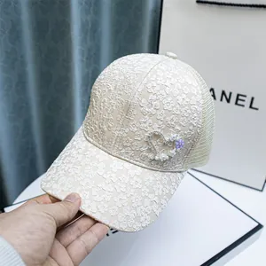 Detail of lace floral embroidery and rhinestone heart on a beige mesh baseball cap