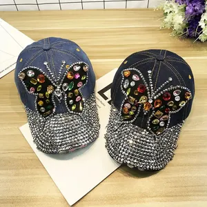 Détail de casquettes en jean avec papillon en strass colorés et visière ornée de cristaux