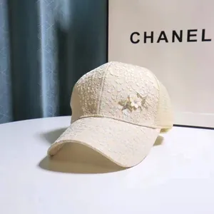 Close-up of lace fabric baseball cap with 3D floral accents and metallic star studs