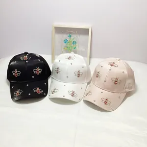 Elegant women's satin baseball caps with rhinestone bee patterns in black, white and pink