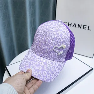 Detail of purple lace baseball cap with pearl heart embellishment and mesh back