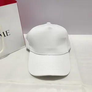 Detail of a minimalist 5-panel white cotton baseball cap with curved reinforced stitching