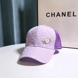 Close-up of purple baseball cap featuring white lace floral embroidery and star ornaments