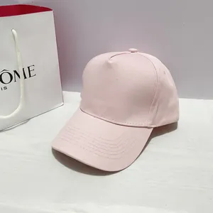 Close-up of light pink baseball cap showing twill fabric and fine stitching on brim