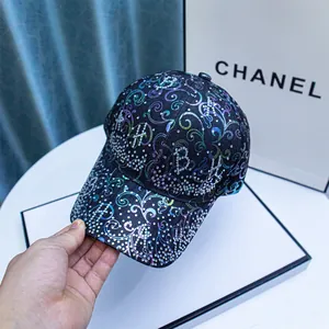 Close-up of baseball cap with rainbow laser floral patterns and rhinestone letters