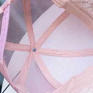 Internal detail of pink trucker hat showing breathable mesh and adjustable snapback closure