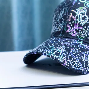 Detail of baseball cap showing intricate rhinestone paisley patterns and colorful glitters