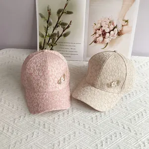 Floral lace baseball caps in pink and beige with rhinestone heart accents on the side