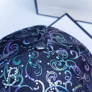 Close-up of black baseball cap with rhinestone letter B and gradient floral pattern