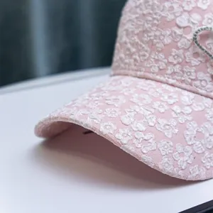 Close-up of pink baseball cap featuring 3D flower embroidery and sparkling rhinestone heart
