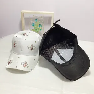 Close-up of baseball cap with rhinestone bee embroidery and metal adjustable buckle