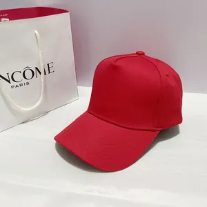 Detail of red five-panel baseball cap with structured twill canvas and curved brim stitching