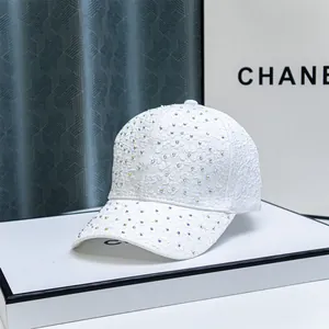 Detailed close-up of white lace floral baseball cap with sparkling colorful rhinestones