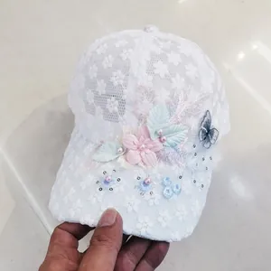 Dettaglio del cappellino da baseball in pizzo floreale 3D con perle e paillettes