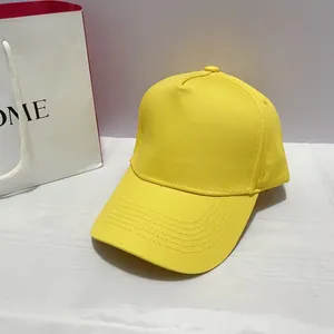 Close-up of bright yellow cotton twill baseball cap showing curved brim and stitching