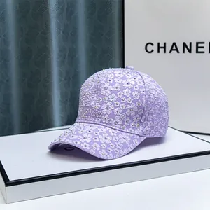 Close-up of purple baseball cap with white floral embroidery and sparkling rhinestones