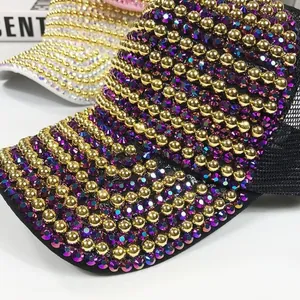 Detailed close-up of luxurious mesh baseball cap with gold beads and sparkling rhinestones