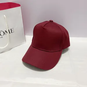 Detailed view of a maroon cotton twill 5-panel baseball cap with copper buckle and hard top