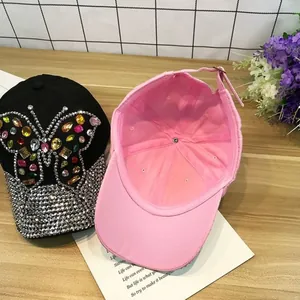 Détail de la casquette avec papillon en strass coloré et bordure sertie de cristaux brillants