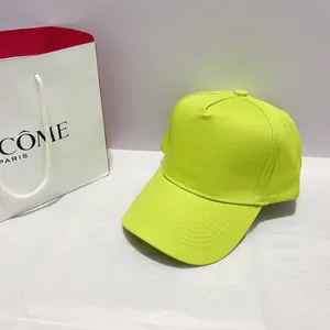 Detail of neon yellow twill baseball cap with curved brim and reinforced stitching