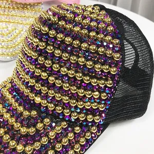 Detailed close-up of crystal rhinestones and golden pearls on a luxury baseball cap